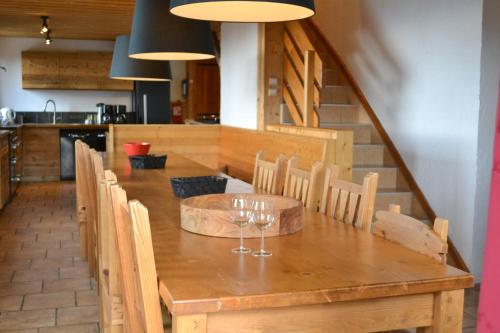 - une table en bois avec des verres à vin dans l'établissement Fabulous chalet La Plagne - ski in-ski out - Sauna with Mont Blanc view, à La Plagne Tarentaise