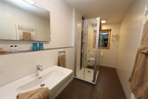 a white bathroom with a sink and a shower at Leidringer Gästehaus GmbH in Rosenfeld