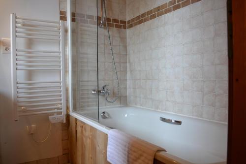 une salle de bain avec baignoire et douche en verre dans l'établissement Fabulous chalet La Plagne - ski in-ski out - Sauna with Mont Blanc view, à La Plagne Tarentaise