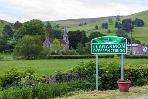 a sign for a lamannonian driving school in a field at West Arms Hotel in Llanarmon Dyffryn-Ceiriog
