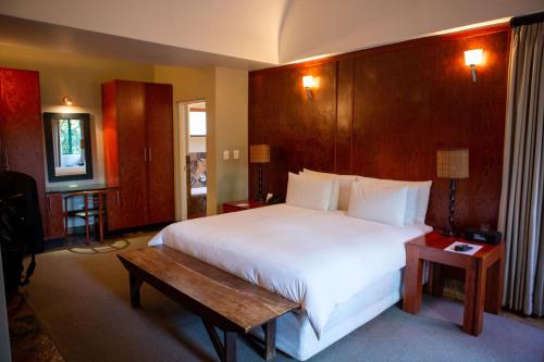 a bedroom with a large white bed and a wooden headboard at Ten Bompas Hotel in Johannesburg