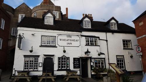 a white building with a sign that reads the wheatstreet inn at The Wheatsheaf Inn in Ludlow