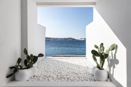 a room with a view of the ocean at Nimbus Mykonos in Agios Stefanos