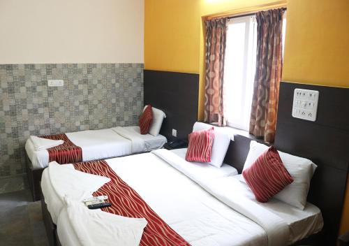 a hotel room with two beds and a window at Season 4 Residences -Thiruvanmiyur Near Tidel park Apollo Proton cancer center and IIT Madras Research Park in Chennai
