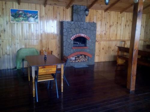 a dining room with a fireplace in a log cabin at Эко отель и баня in Kosharishche