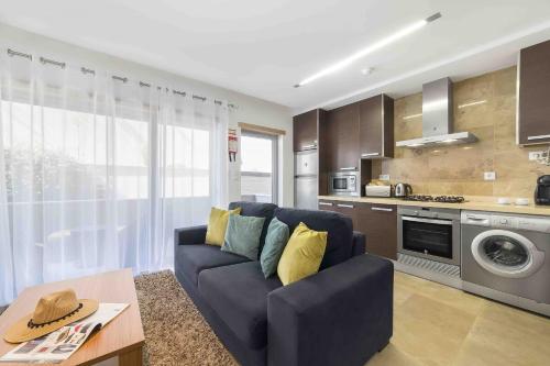 un soggiorno con divano blu e una cucina di Baia Residence 3 - Holiday Apartments - By SCH a São Martinho do Porto