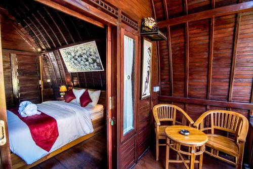 Un dormitorio con una cama y una mesa y sillas. en Sekar Ayu Spa Salon & Bungalow, en Nusa Penida