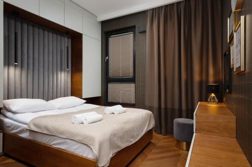 a bedroom with two towels on a bed at Apartments Konstruktorska by Renters Prestige in Warsaw