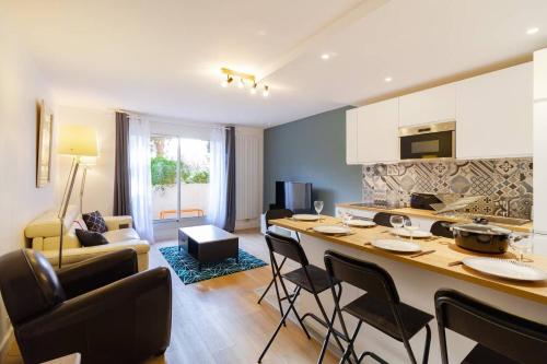 een keuken en een woonkamer met een tafel en stoelen bij 2 chambres Terrasse Parking Toulouse Centre Gare in Toulouse