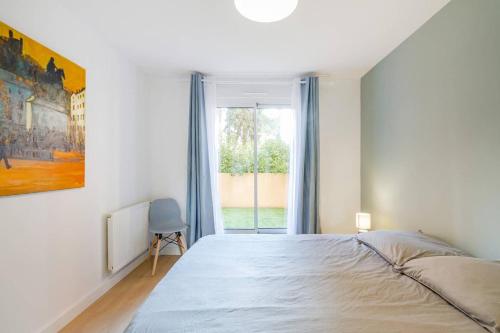 une chambre avec un grand lit et une fenêtre dans l'établissement 2 chambres Terrasse Parking Toulouse Centre Gare, à Toulouse