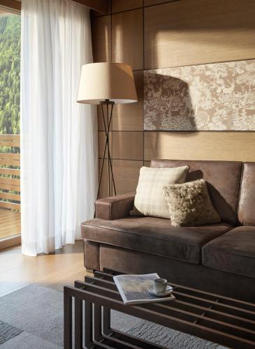 a living room with a couch and a table at Lefay Resort & SPA Dolomiti in Pinzolo