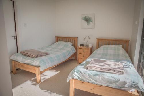 two twin beds sitting in a room with at Sea Loch View Holiday Home in Portree