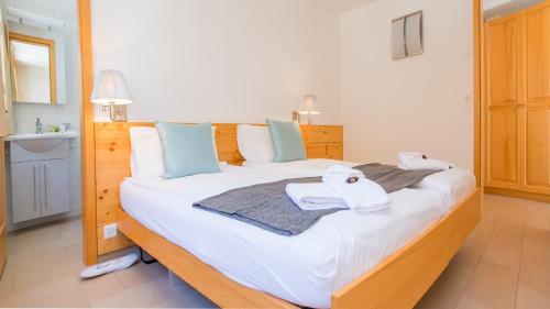 a bedroom with a large white bed with towels on it at Chalet Luna in Wengen