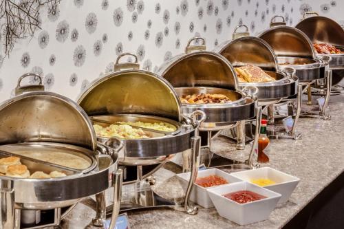 a row of pans filled with different types of food at Crowne Plaza Milwaukee South, an IHG Hotel in Milwaukee