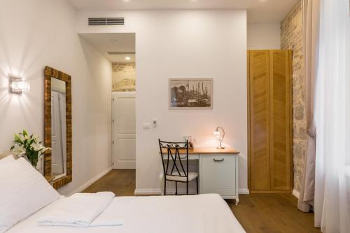 a bedroom with a bed and a desk with a chair at Pellegrini Luxury Rooms in Split