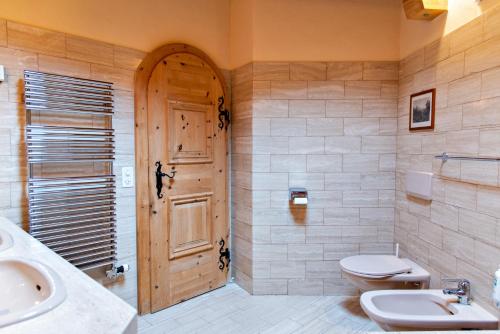 a bathroom with a toilet and a sink and a door at Chesa Romana - Silvaplana in Silvaplana