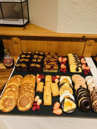 a bunch of different types of pastries on a table at Residence Hotel Alpinum in Campo Tures