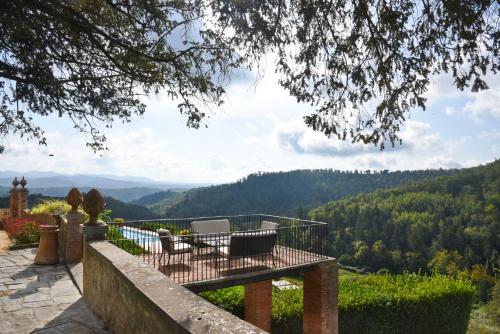 a balcony with chairs and a view of the mountains at Wine Resort Dievole in Vagliagli