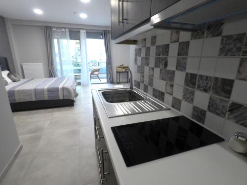 een keuken met een wastafel en een bed in een kamer bij Dreamstudio II in Volos