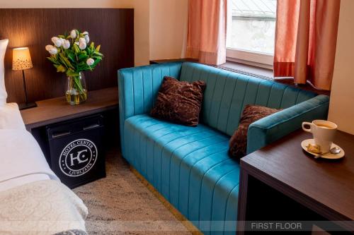 a blue couch in a room with a vase of flowers at Center Ljubljana in Ljubljana