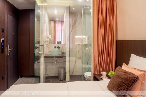 um quarto com uma cabina de duche em vidro e uma cama em Center Ljubljana em Ljubljana