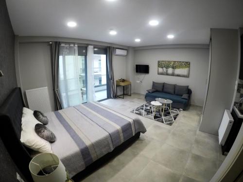 een slaapkamer met een bed en een blauwe bank bij Dreamstudio II in Volos