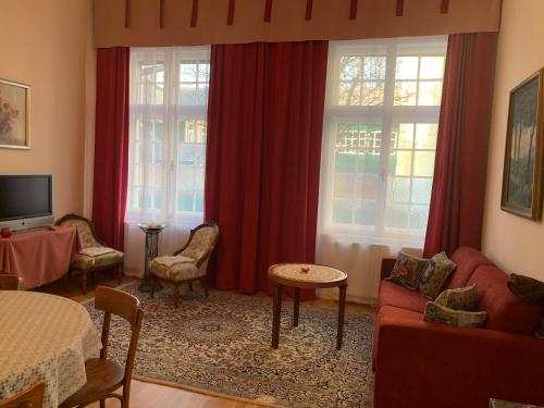 a living room with a red couch and two windows at Villa Pazelt Top2 in Bad Vöslau