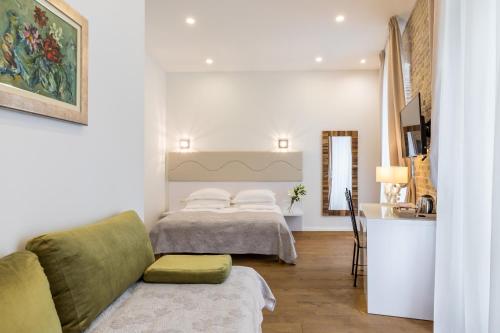 a bedroom with two beds and a couch and a television at Pellegrini Luxury Rooms in Split