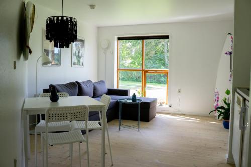 a living room with a couch and a table and chairs at Feriehus Thy - I hjertet af Thy in Thisted