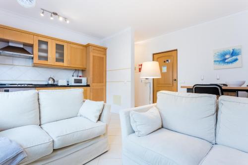 a living room with a white couch and a kitchen at IM on Centro Historico in Lagos
