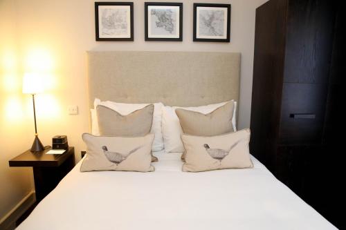 a bedroom with a large white bed with pillows at De Vere Latimer Estate in Chesham