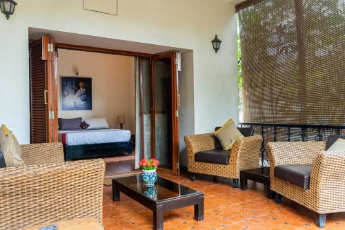a living room with chairs and a bed and a table at StayVista at Firefly Homestay with Pvt Pool & Terrace Access in Bangalore