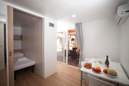 una habitación con una mesa con un plato de comida. en Mediteran Travel Mobile Homes in Camping Terme Čatež, en Brežice