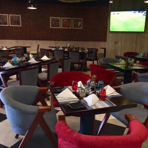 a dining room with tables and chairs and a screen at Hotel English Point Marina & Spa in Mombasa