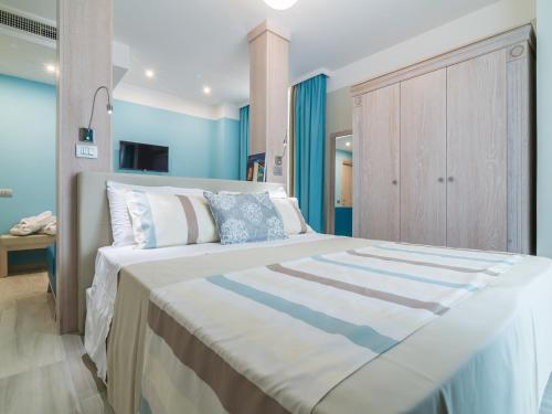 ein Schlafzimmer mit einem großen Bett mit blauen Wänden in der Unterkunft L'Ambasciata Hotel de Charme in Cagliari