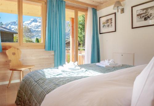 - une chambre avec un lit et une fenêtre dans l'établissement Chalet Stella Penthouse Residence, à Wengen