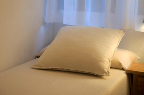 a white pillow sitting on top of a bed at Hotel Florido in Sort