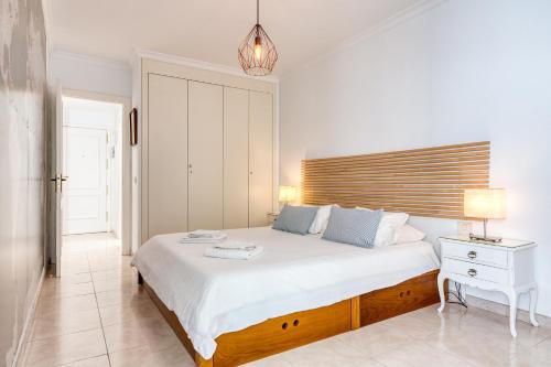 ラスパルマス・デ・グランカナリアにあるApartamento Canterasのベッドルーム1室(大型ベッド1台、木製ヘッドボード付)