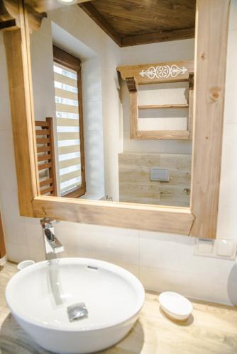 a bathroom with a white sink and a mirror at Sielanka Apartamenty SPA in Białka Tatrzanska