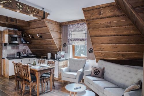 a kitchen and living room with a table and a couch at Sielanka Apartamenty SPA in Białka Tatrzanska
