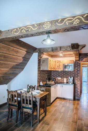 a kitchen with a table and chairs in a room at Sielanka Apartamenty SPA in Białka Tatrzanska
