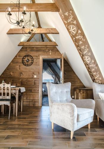 a living room with a vaulted ceiling and a table and chairs at Sielanka Apartamenty SPA in Białka Tatrzanska
