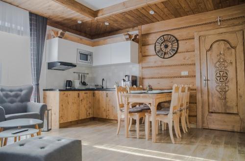 a kitchen and dining room with a table and chairs at Sielanka Apartamenty SPA in Białka Tatrzanska