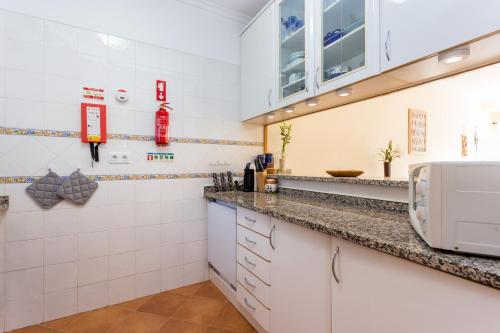 een keuken met witte kasten en een aanrechtblad bij IM On Meia Praia Terrasse in Lagos