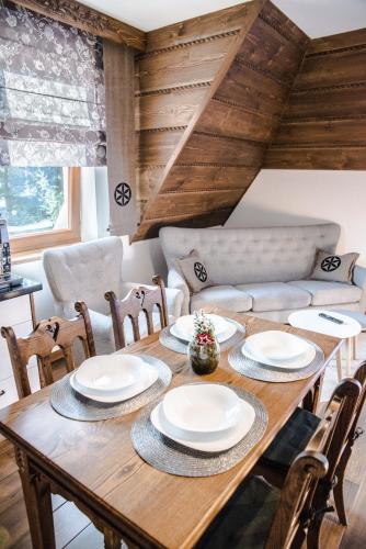 a dining room with a wooden table and chairs at Sielanka Apartamenty SPA in Białka Tatrzanska