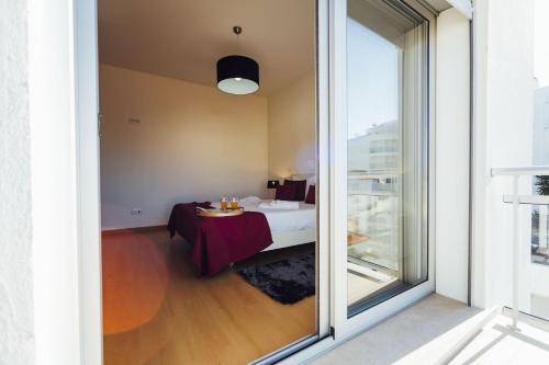 a room with a table and a large window at Muralha - By SCH in Nazaré