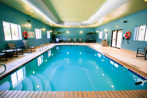 a large swimming pool in a hotel room with blue walls at Holiday Inn Express Hotel & Suites Baton Rouge -Port Allen by IHG in Port Allen
