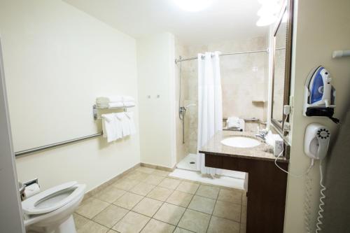a bathroom with a toilet and a shower and a sink at Staybridge Suites Austin Airport by IHG in Austin