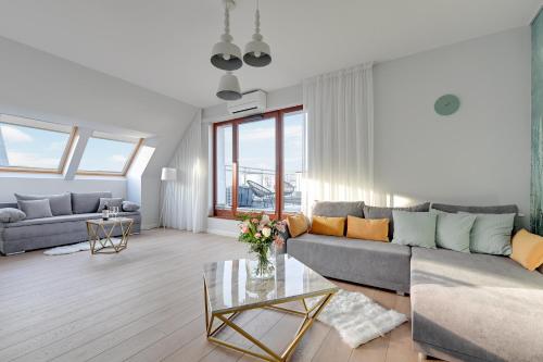 a living room with a couch and a table at GRANO APARTMENTS Gdańsk Motława SPA & Wellness in Gdańsk