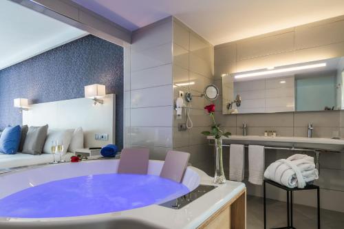 Habitación con baño con bañera azul grande. en Aparthotel Esquinzo Y Monte Del Mar en Playa Jandia